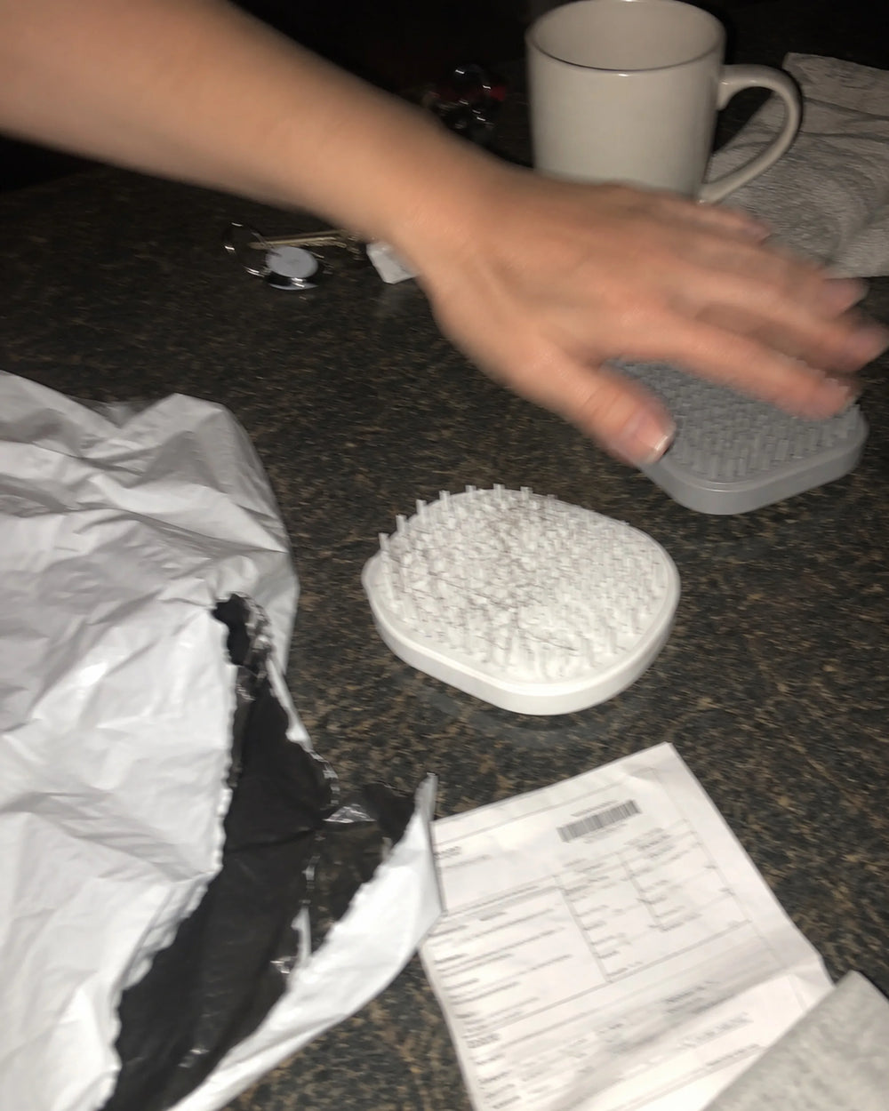 A failed bristle-pad hair catcher next to its return paperwork